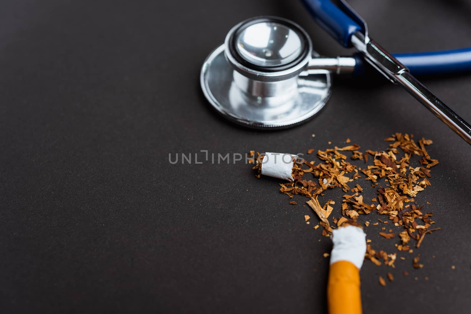 31 May of World No Tobacco Day, no smoking, close up of broken pile cigarette or tobacco and doctor stethoscope on black background with copy space, and Warning lung health concept