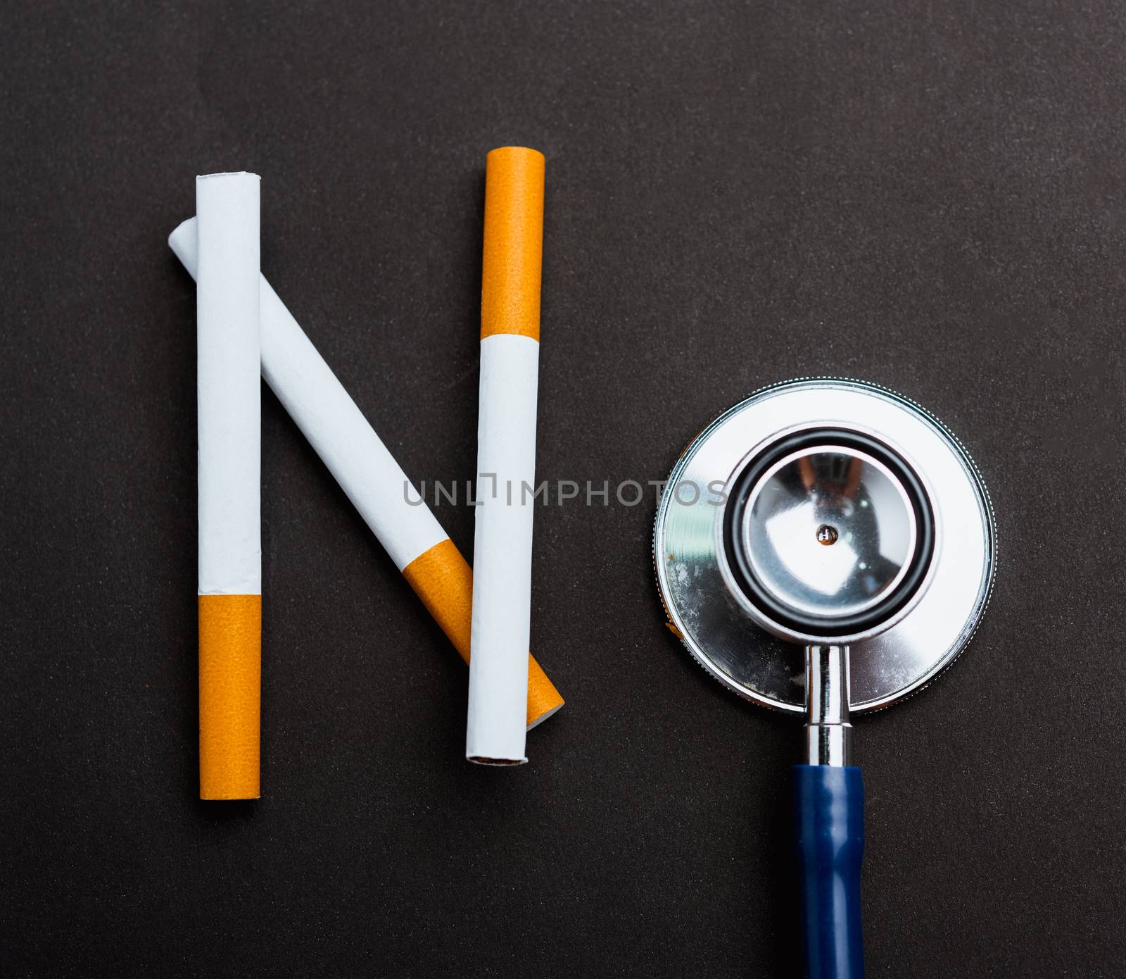 31 May of World No Tobacco Day, no smoking close up word NO spelled text of the pile cigarette or tobacco and doctor stethoscope on black background with copy space, and Warning lung health concept