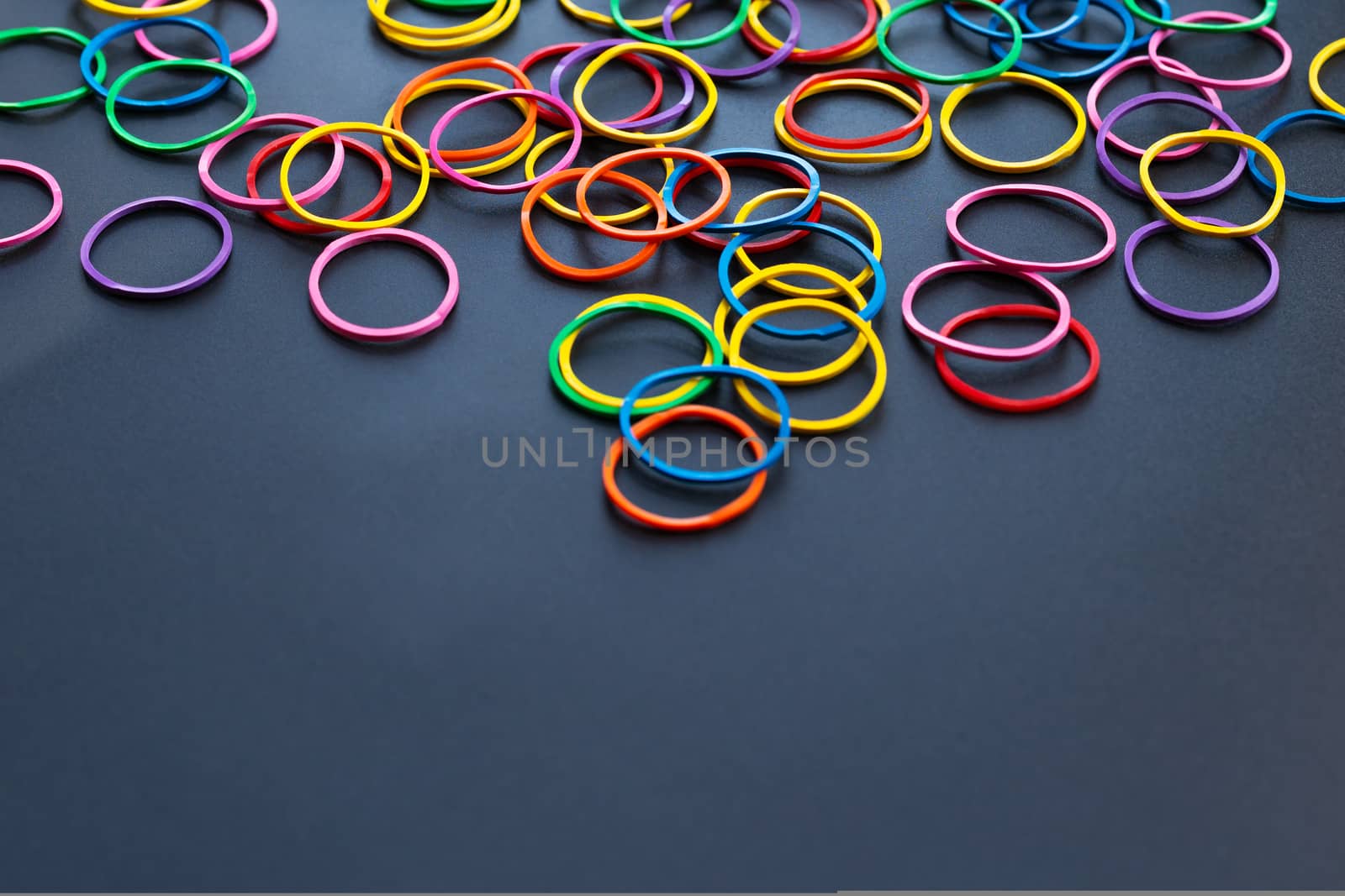 Teamwork concept. group of colorful rubber band on black background with copy space