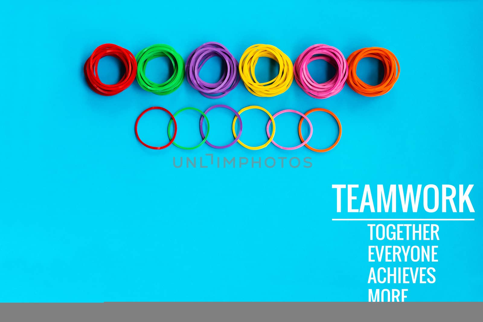 Teamwork concept. group of colorful rubber band on blue background with word Teamwork, Together, Everyone, Achieves and More
