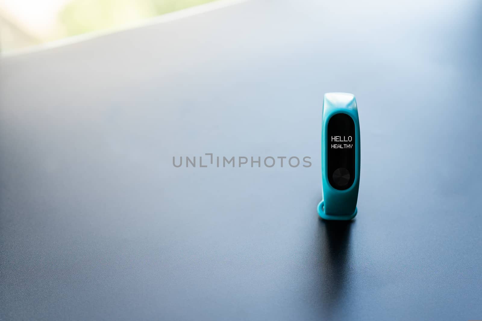 fitness smart band device blue color on black background with word Hello healthy