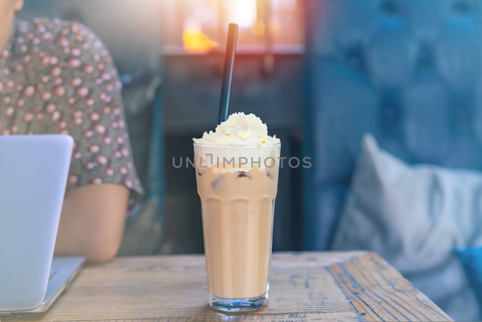 ice mocha coffee on wooden table with working man using laptop