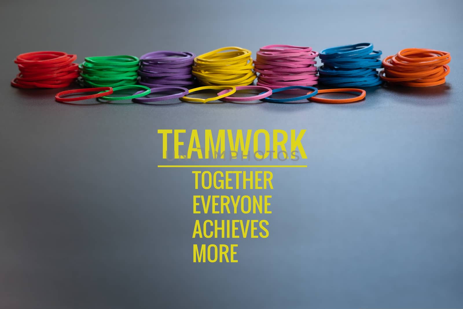 Teamwork concept. group of colorful rubber band on black background with word Teamwork, Together, Everyone, Achieves and More