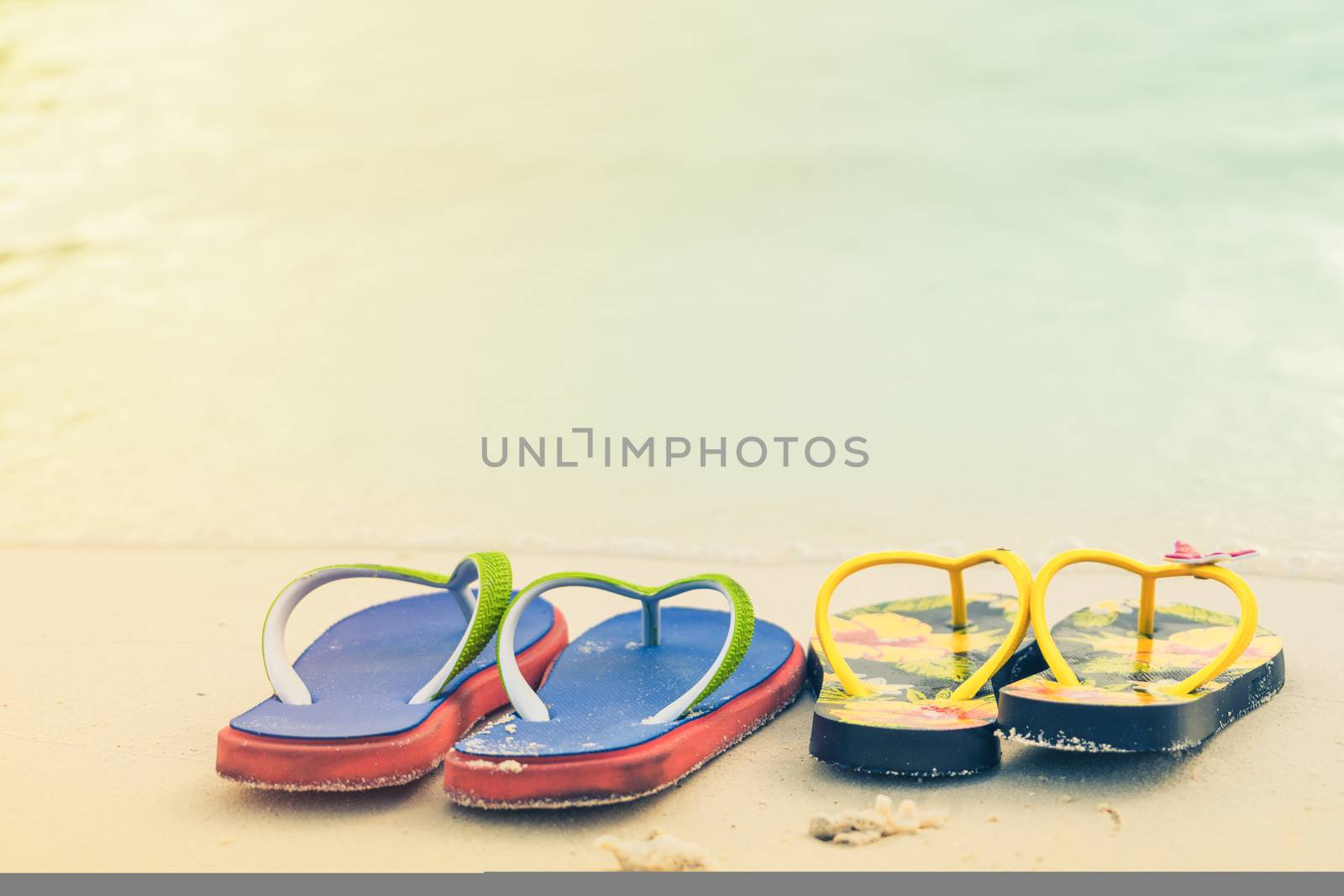2 slippers on the white sand beach, travel and vacation time