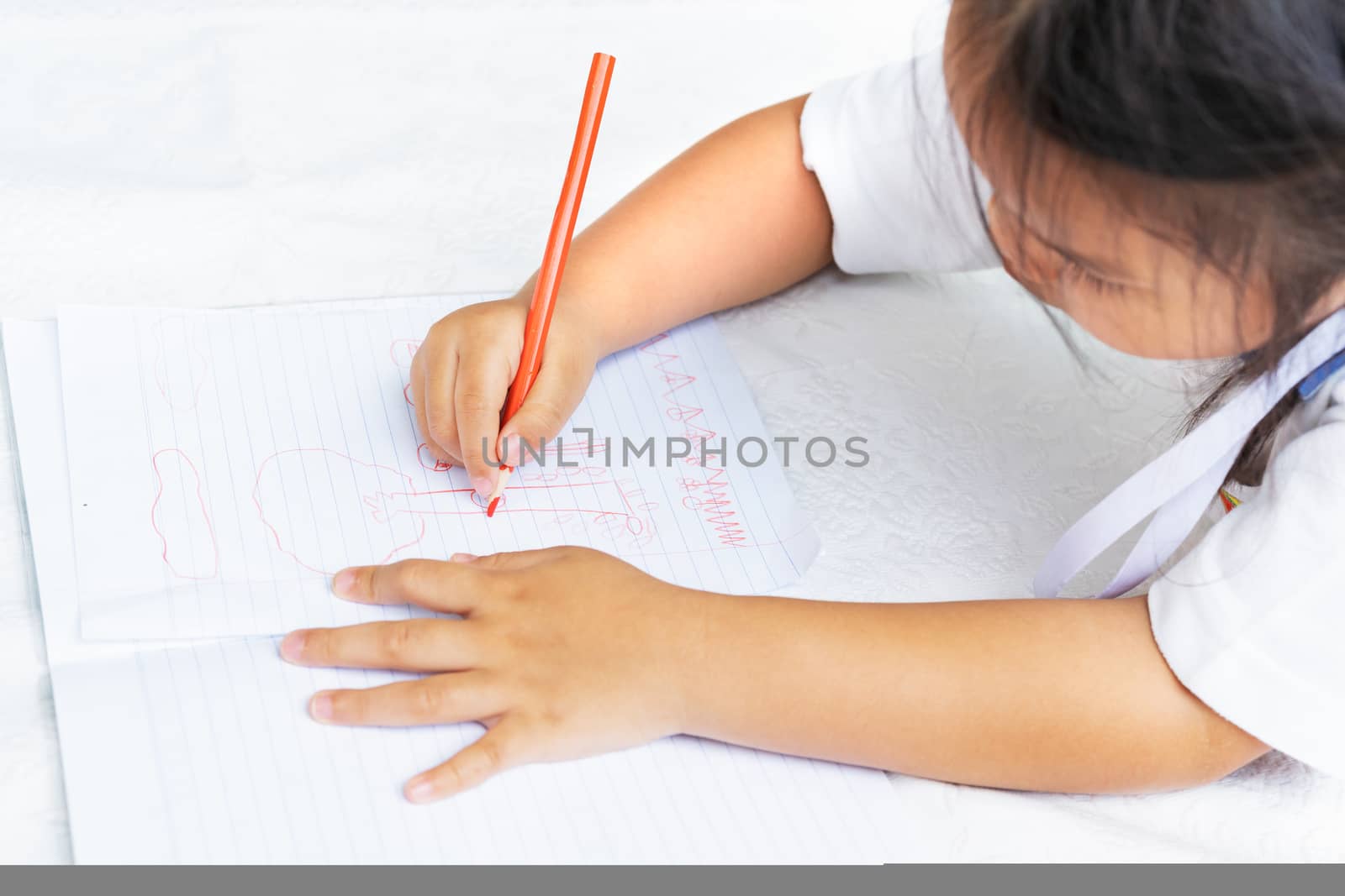 little girl writes to writing-books. The decision of lessons. girl lay down drawing the picture