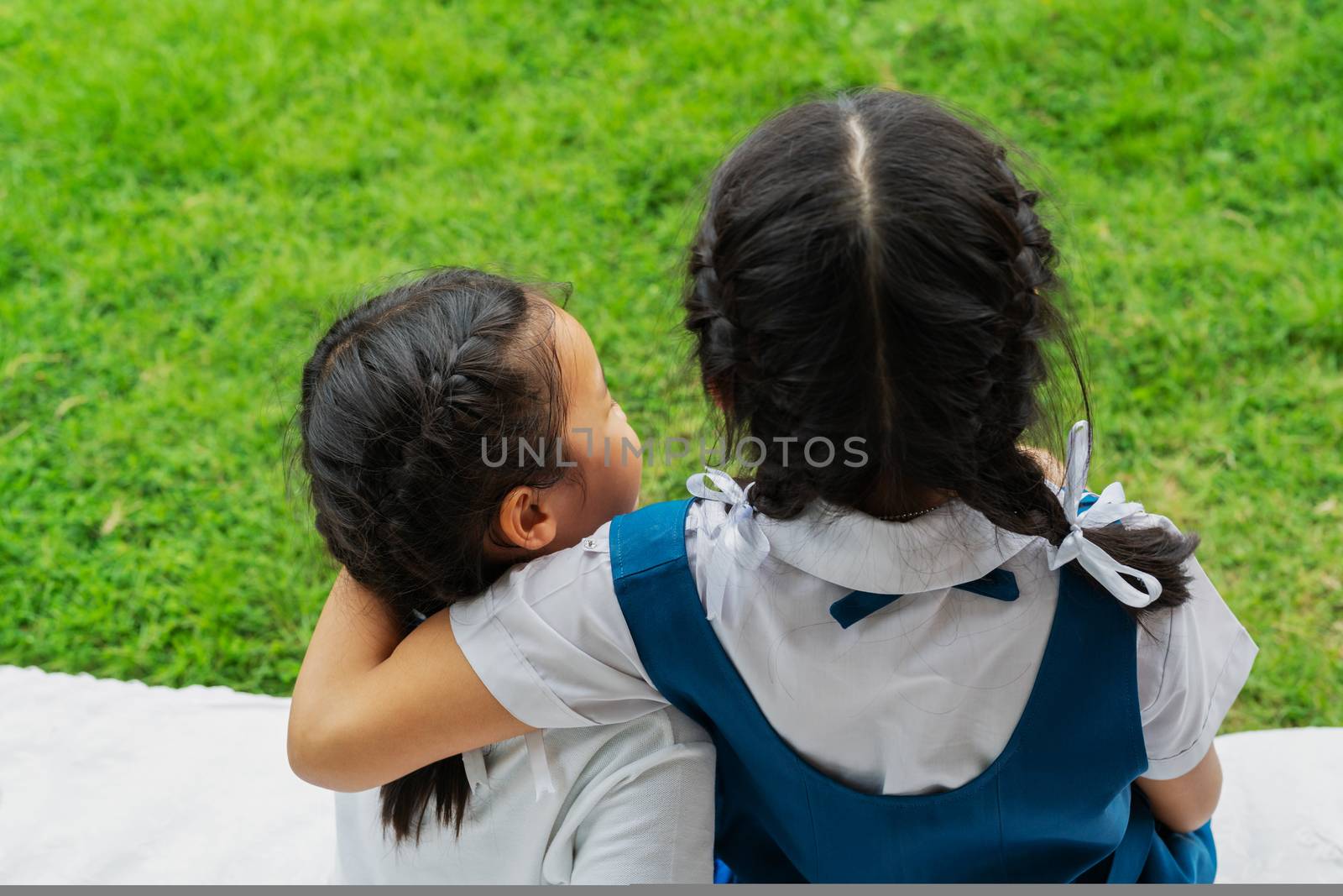 two little asian girls sisters hugging happy post in school uniform, back to school concept