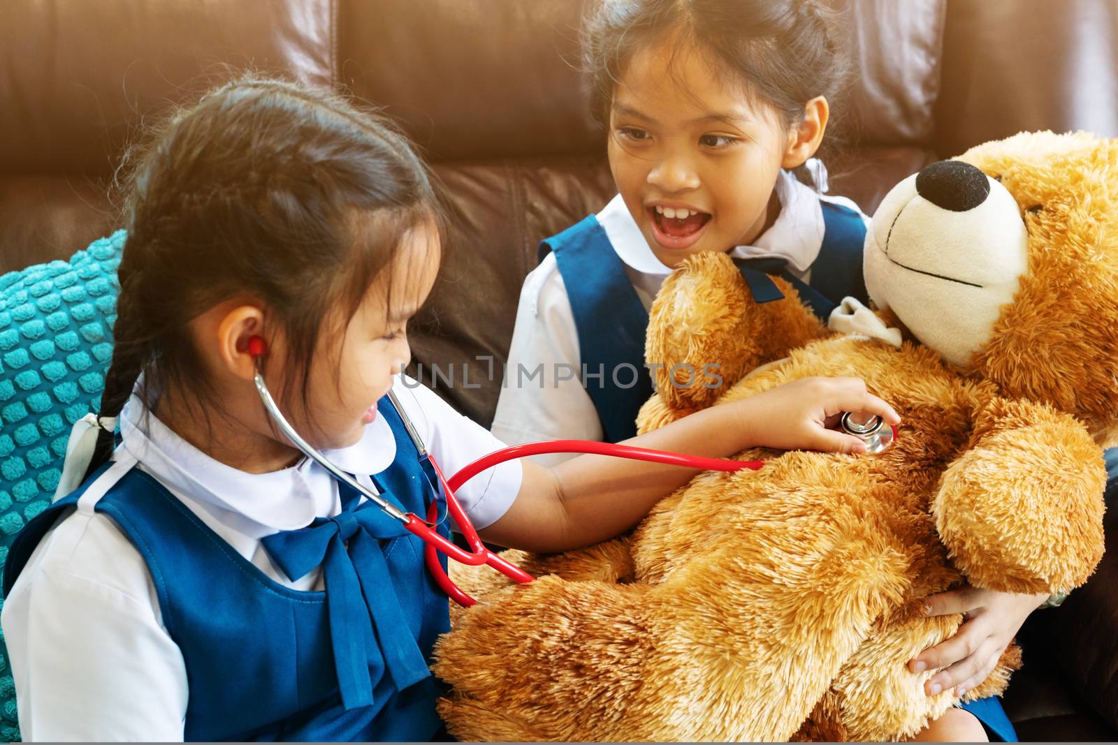 two little girl are smiling and playing doctor with stethoscope. Kid and health care concept.