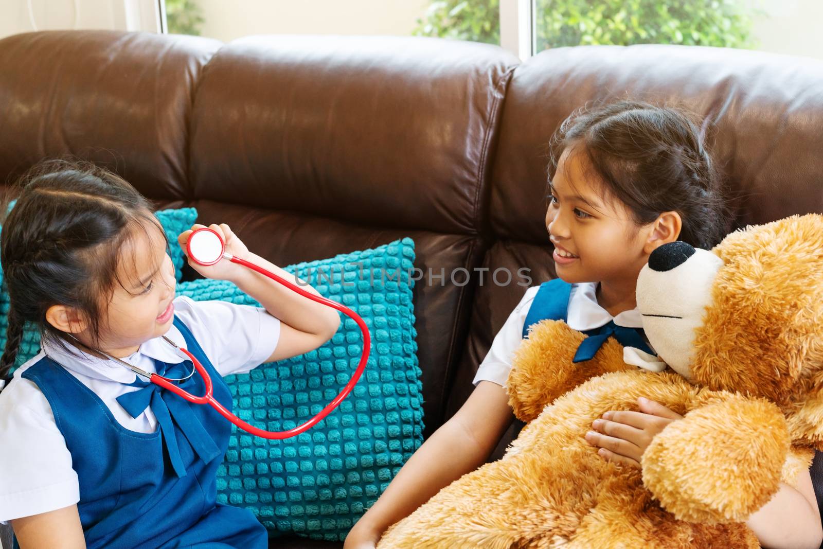 two little girl are smiling and playing doctor with stethoscope. Kid and health care concept.