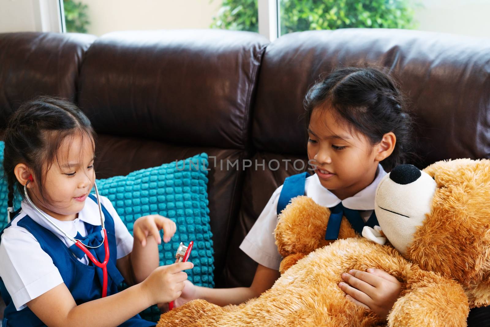 two little girl are smiling and playing doctor with stethoscope. Kid and health care concept.
