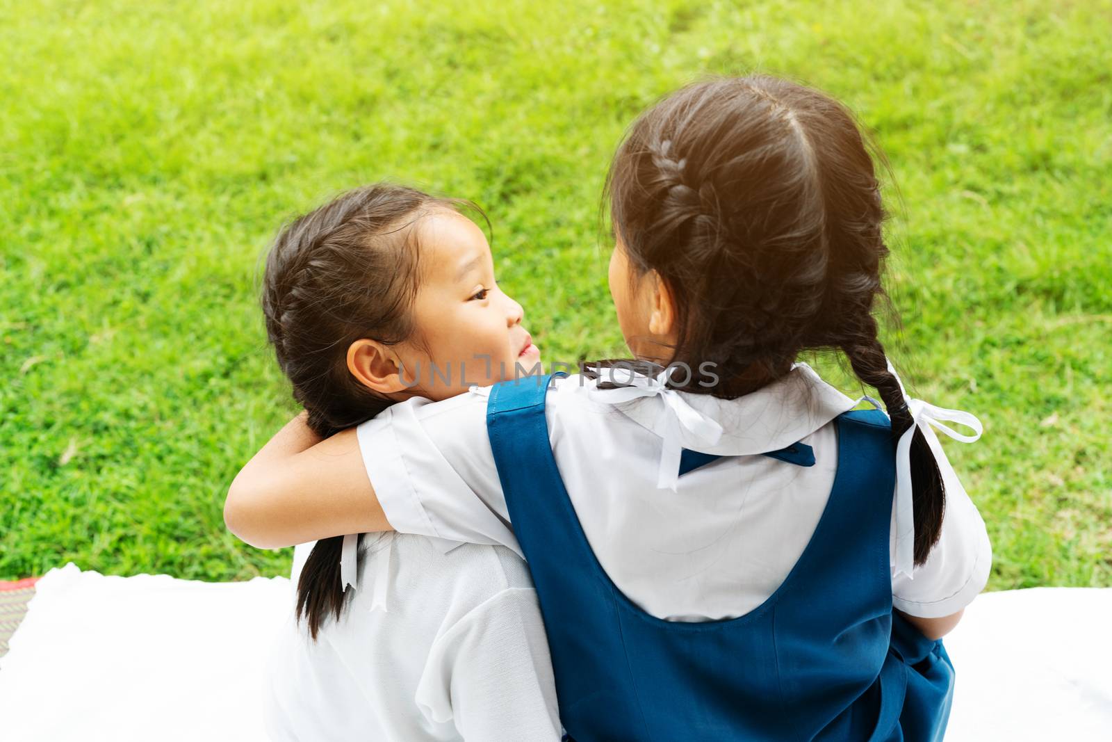 two little asian girls sisters hugging happy post in school uniform, back to school concept