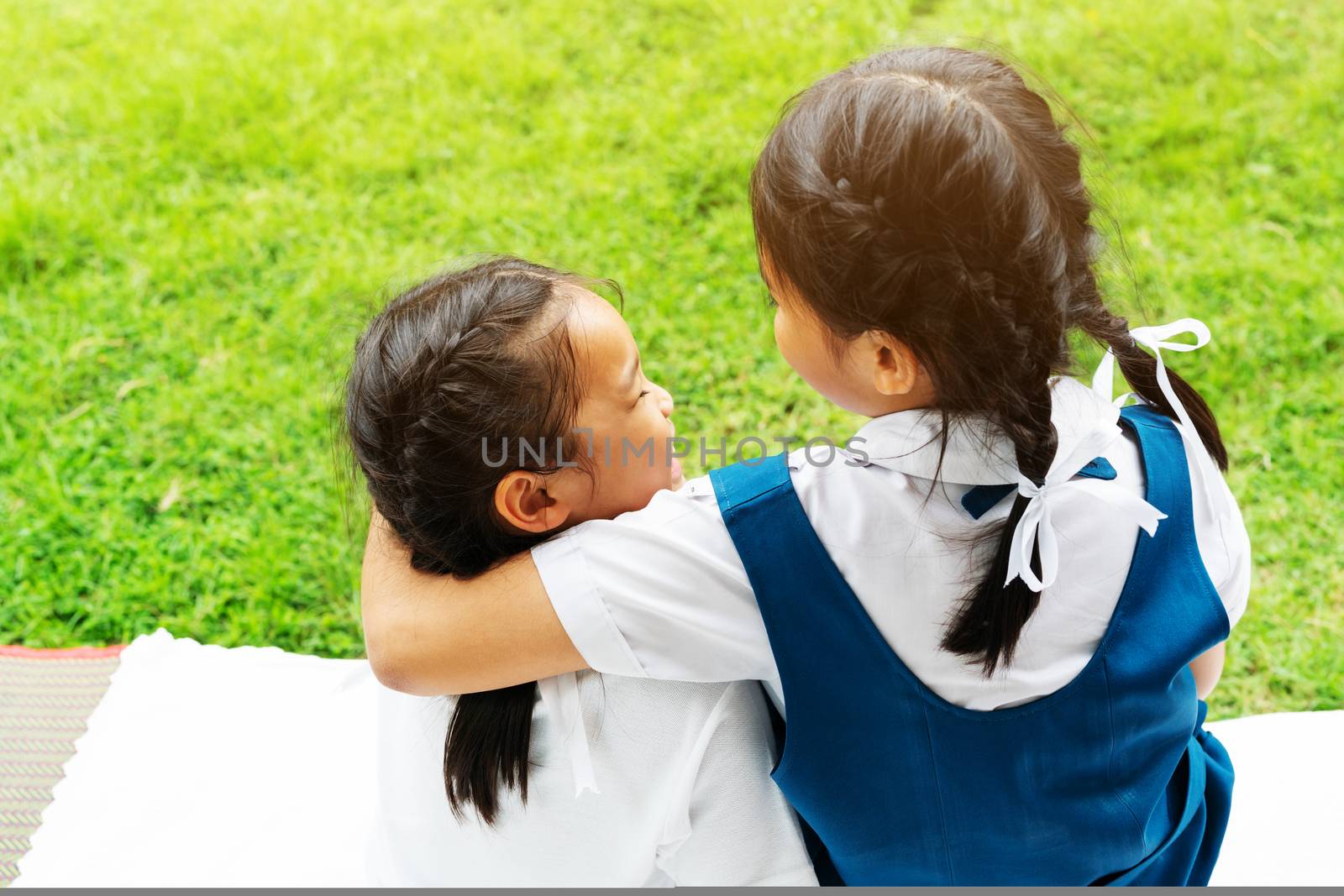 two little asian girls sisters hugging happy post in school uniform, back to school concept