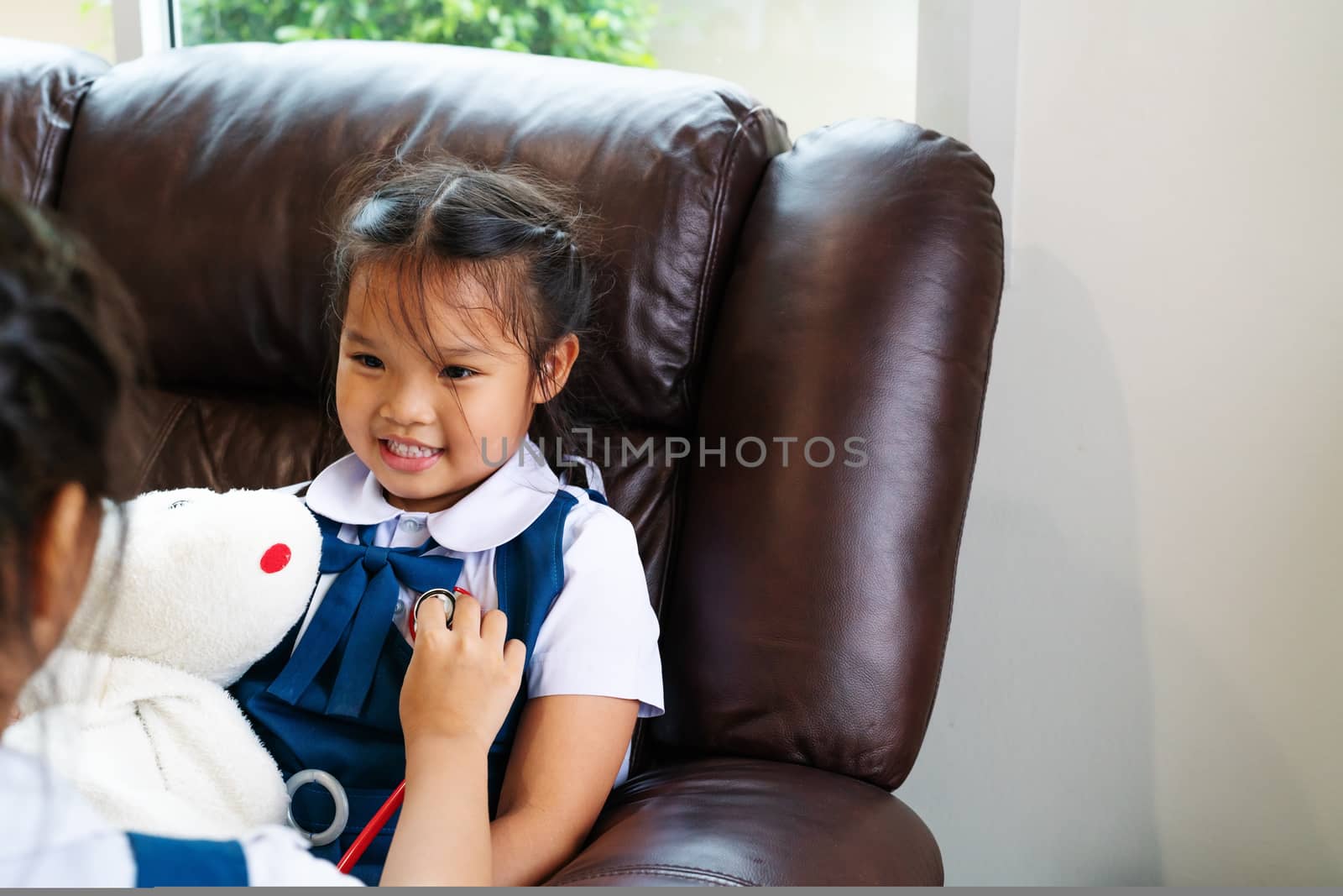 two little girl are smiling and playing doctor with stethoscope. Kid and health care concept.