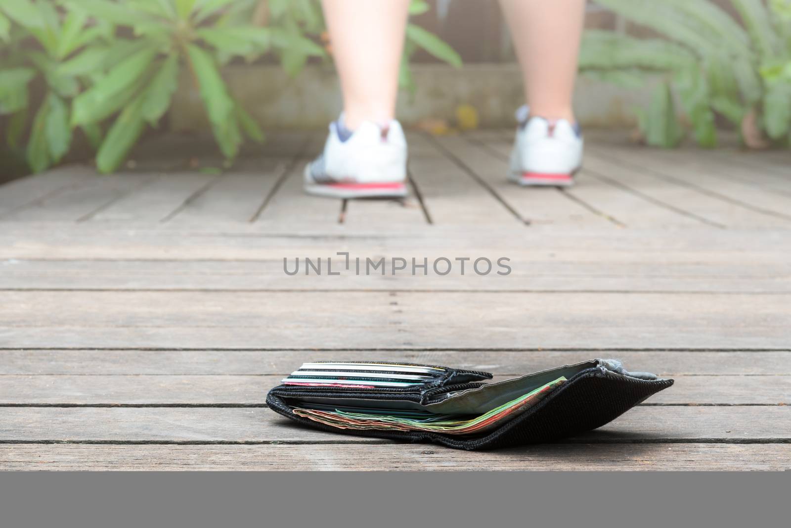 lost wallet with money and card on the walkway. Close-up wallet lying on sidewalk in during the trip