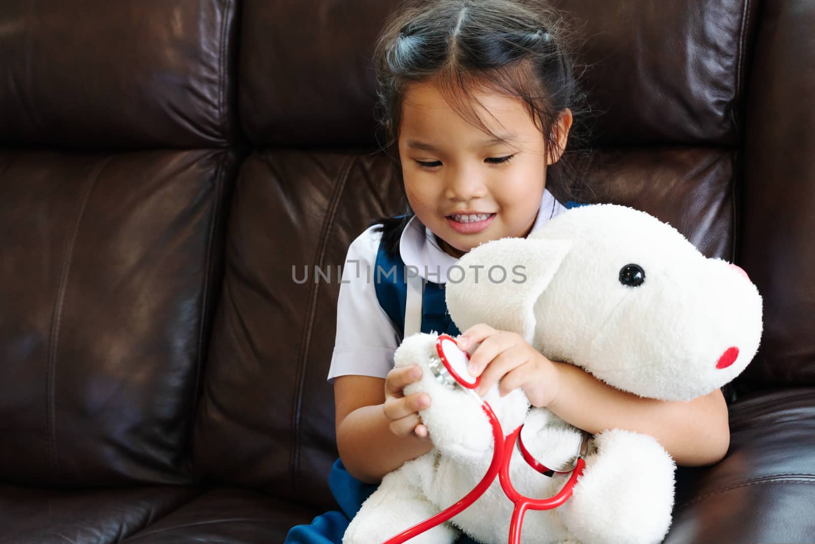 little girl are smiling and playing doctor with stethoscope. Kid and health care concept.