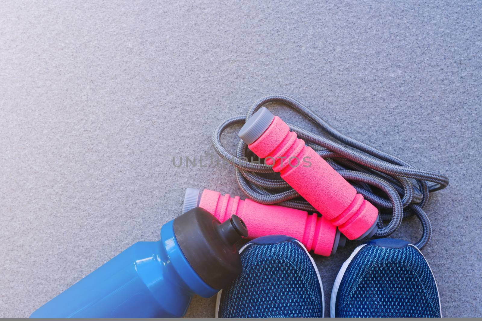 Jump rope, Running shoes, and drink bottle on the ground