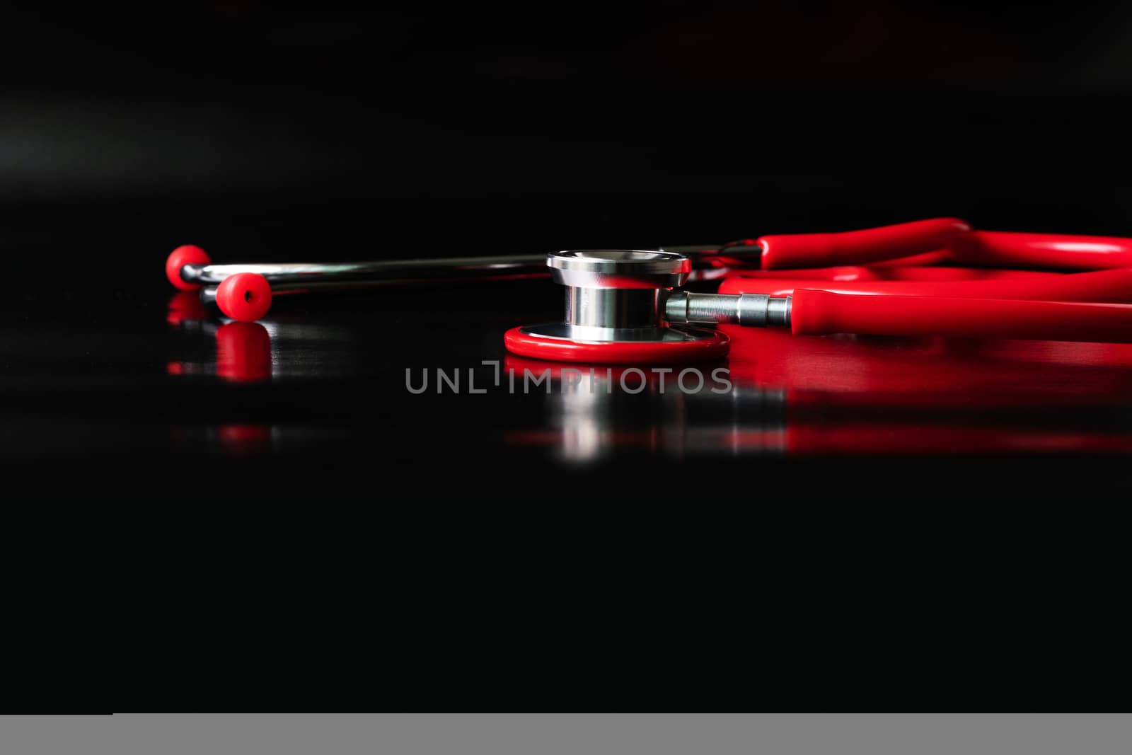 red stethoscope on black background. Healthcare and medicine concept