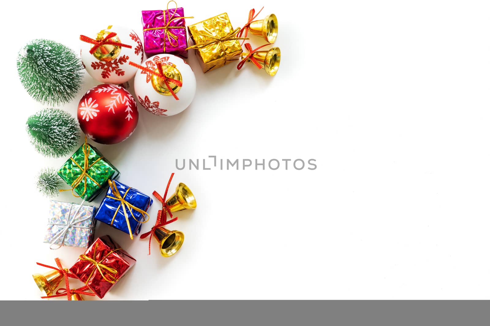 Christmas background concept. Christmas gift box and tree with golden bells, pine cones, red and white ball on white background, top view
