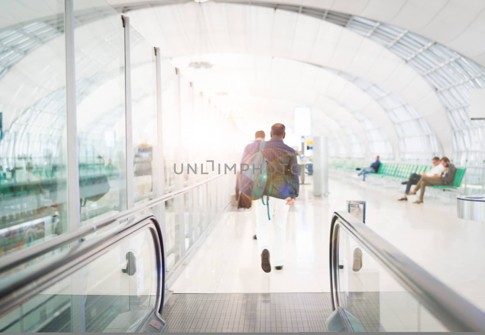 traveler with travel bag or luggage walking in the airport terminal walkway for air traveling. blur motion