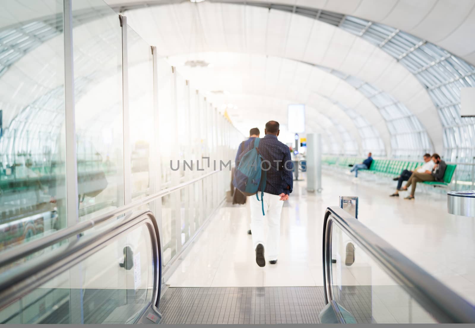traveler with travel bag or luggage walking in the airport terminal walkway for air traveling. blur motion
