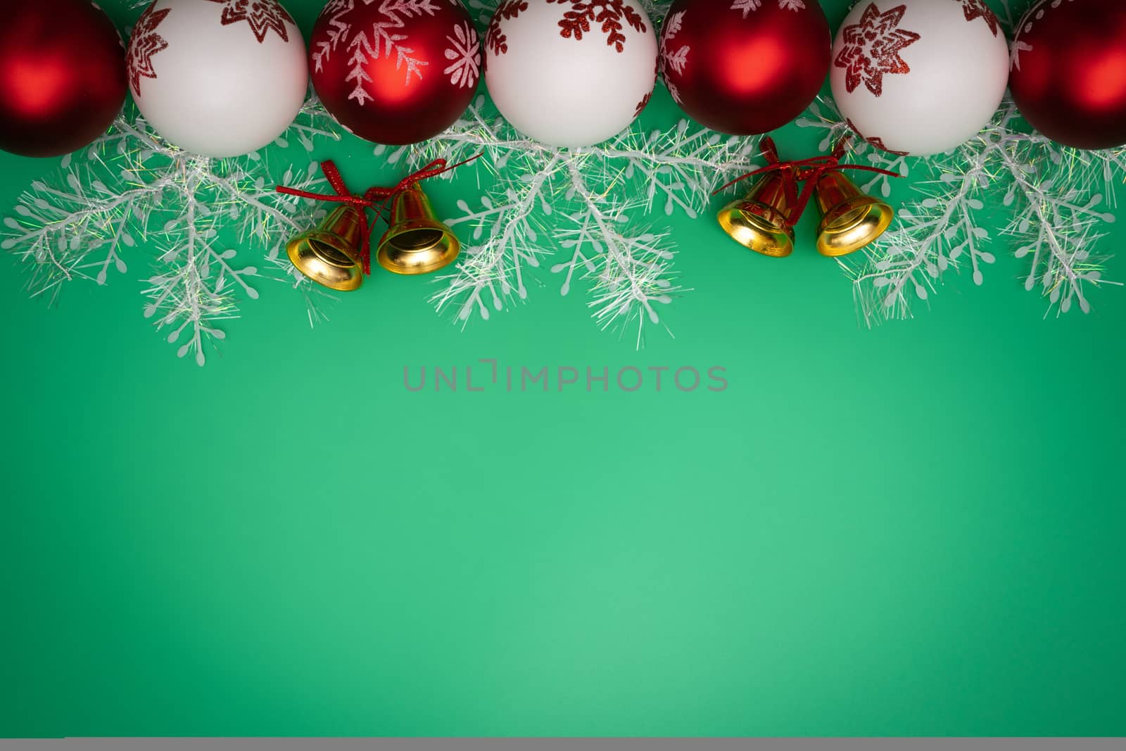 Christmas composition. Christmas gift, bell and ball on green background. Flat lay, top view, copy space