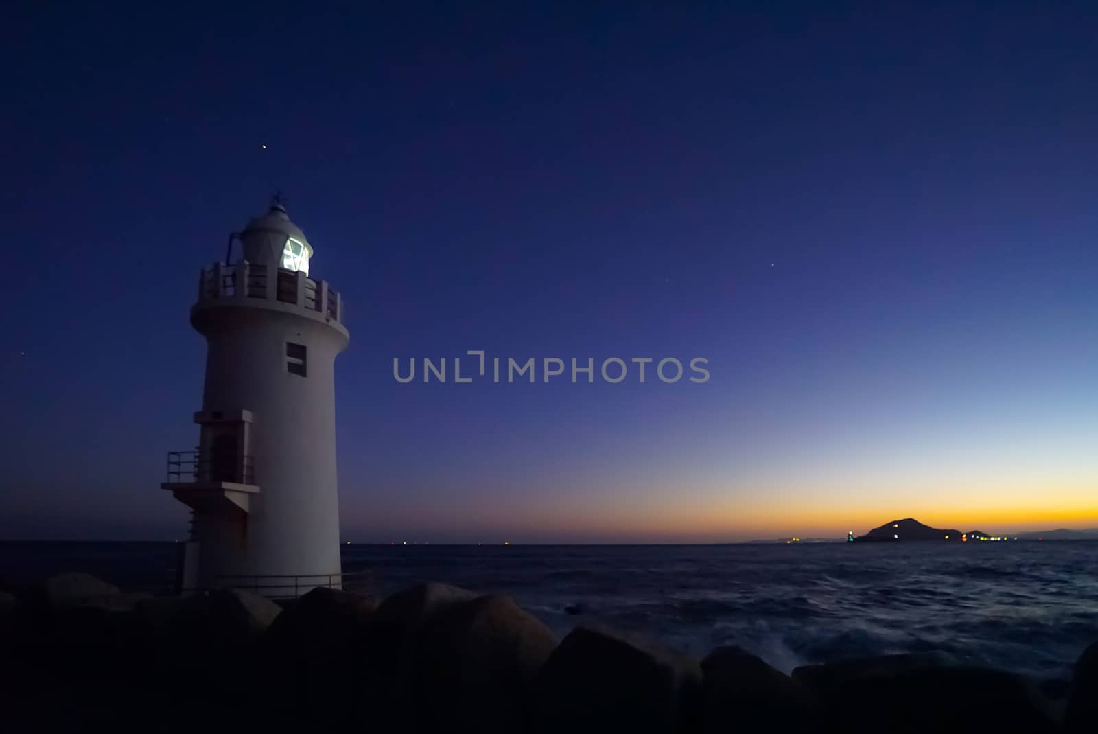 A beautiful night sky behind a White Lighthouse.