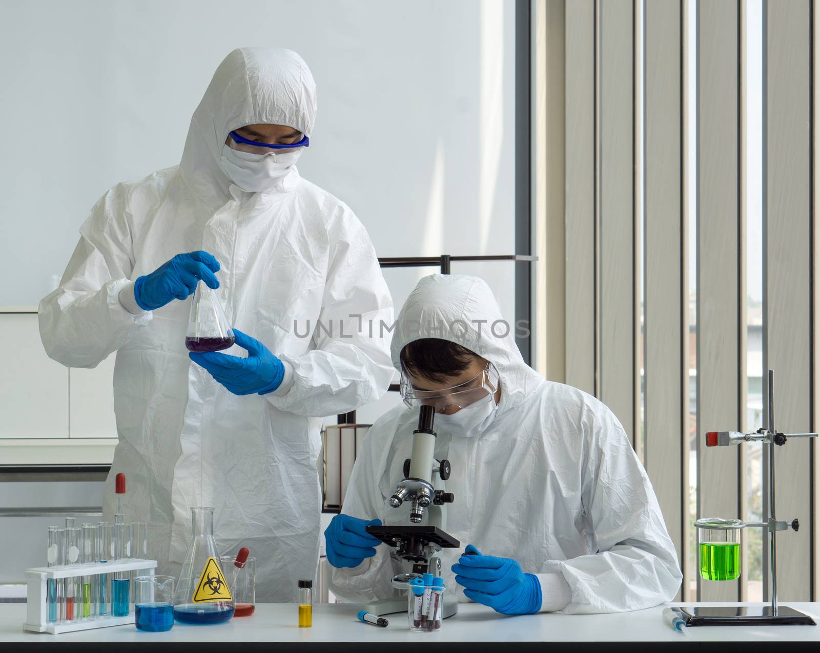 Researchers use microscopes to look at blood samples of infected people.
Coronavirus disease 2019 (COVID-19) testing process in a laboratory preventing the spread of viral research.