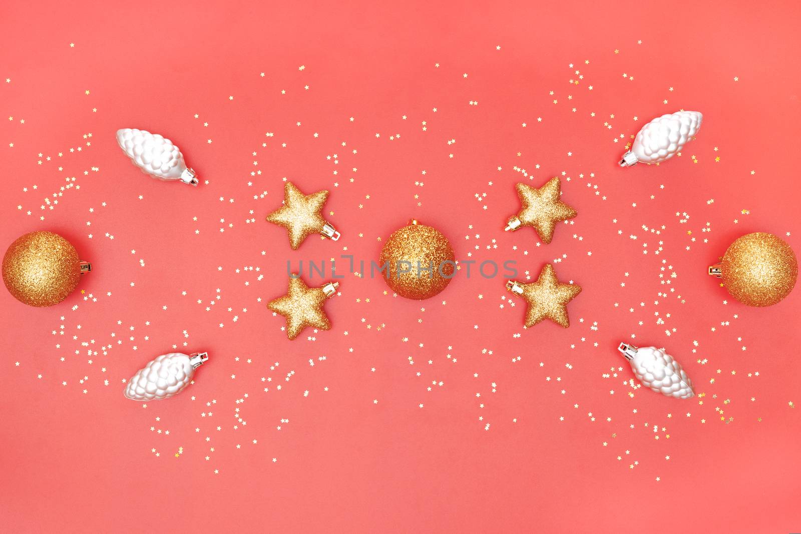 golden ball, star and bell on pink living coral background for birthday, christmas or wedding ceremony
