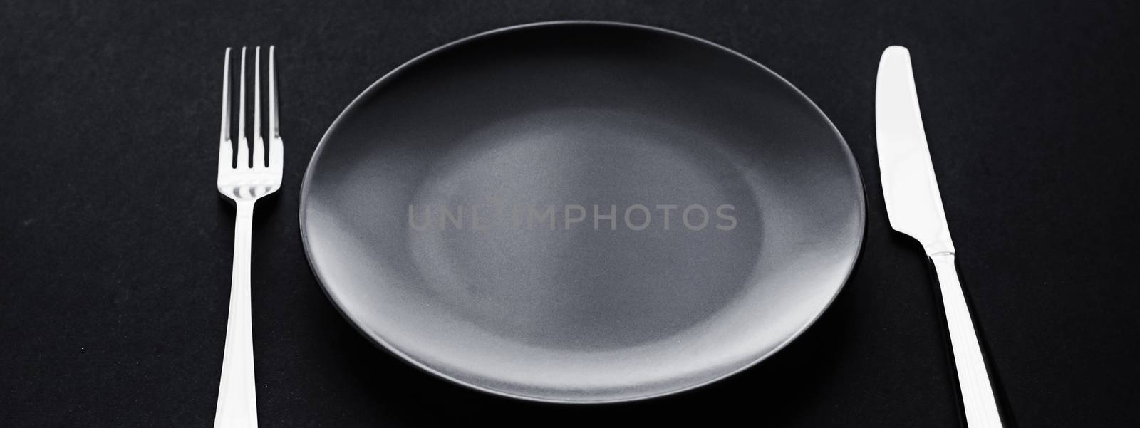 Empty plates and silverware on black background, premium tableware for holiday dinner, minimalistic design and diet concept