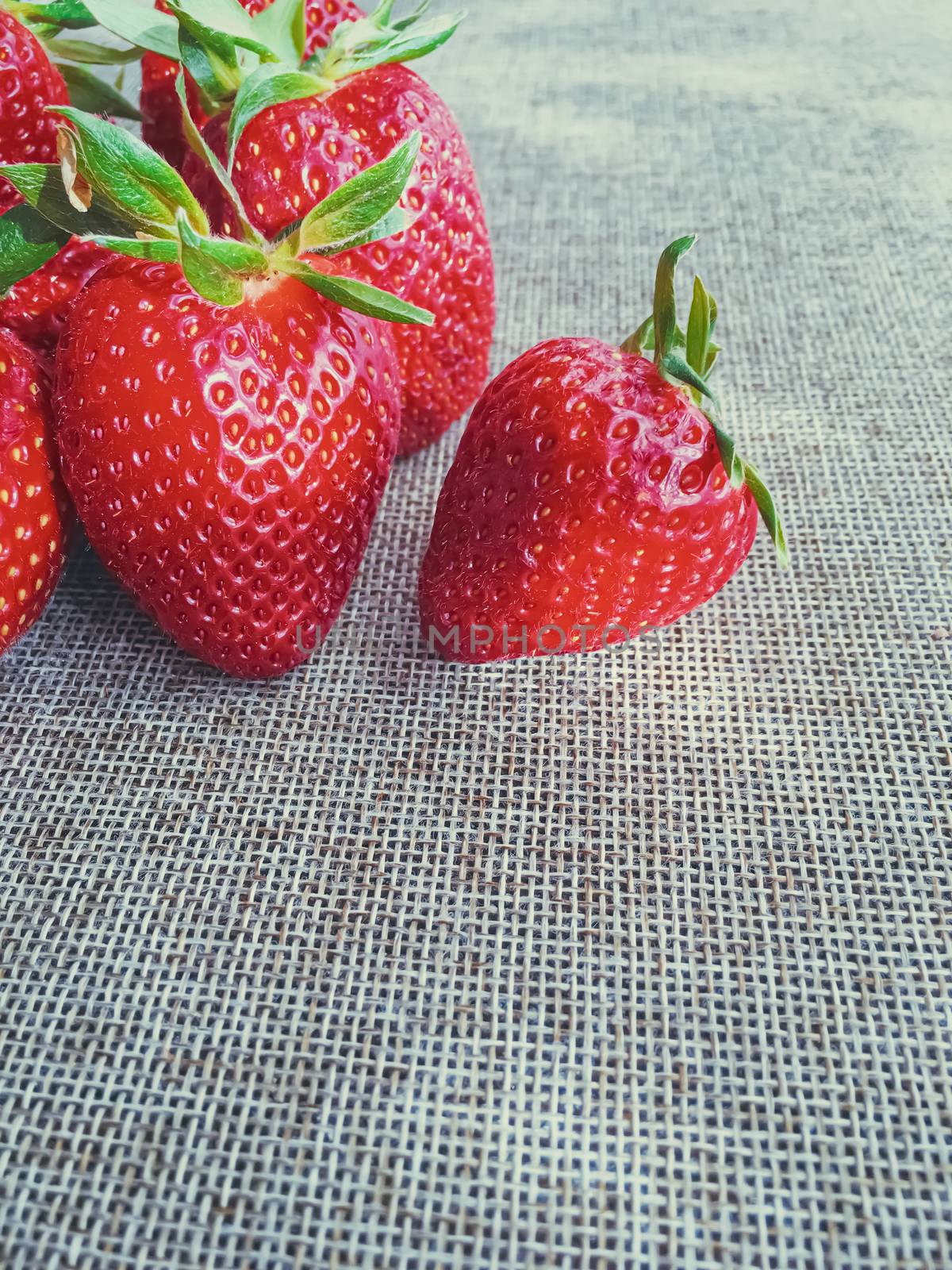 Organic strawberries on rustic linen background by Anneleven