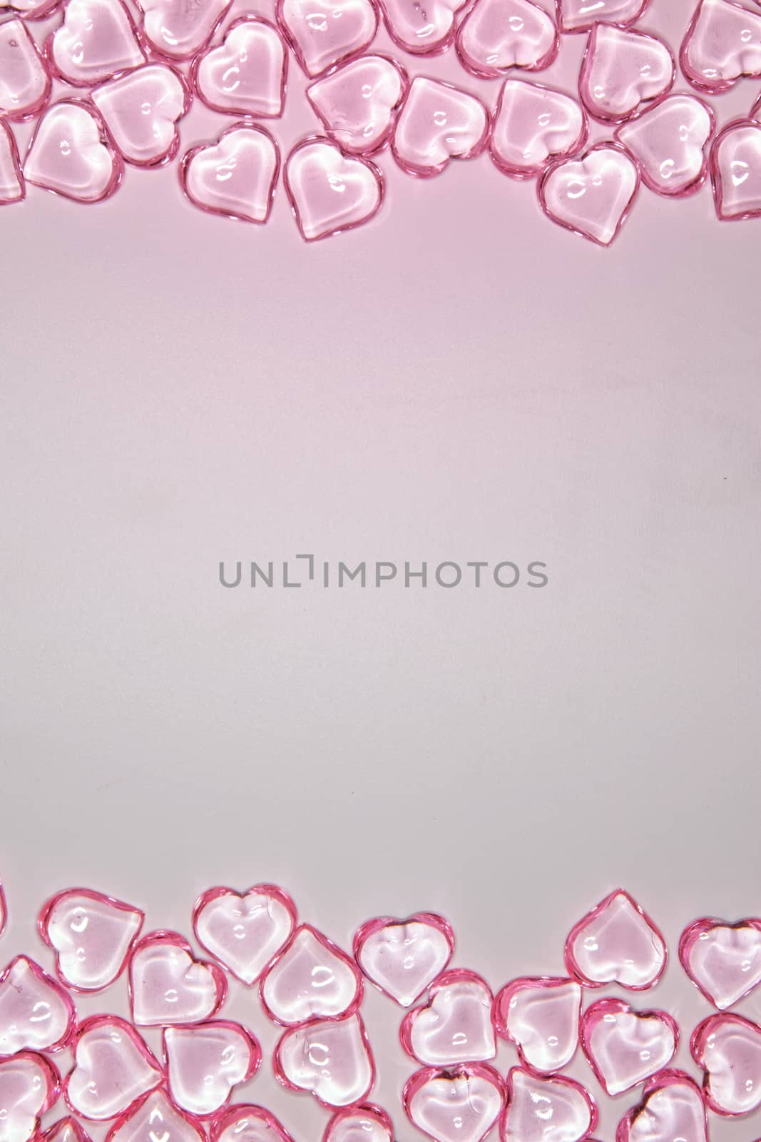 Background from small pink transparent hearts. Love heart frame. Happy mother's day concept. Love symbol. Holiday card background, copy space for text.
