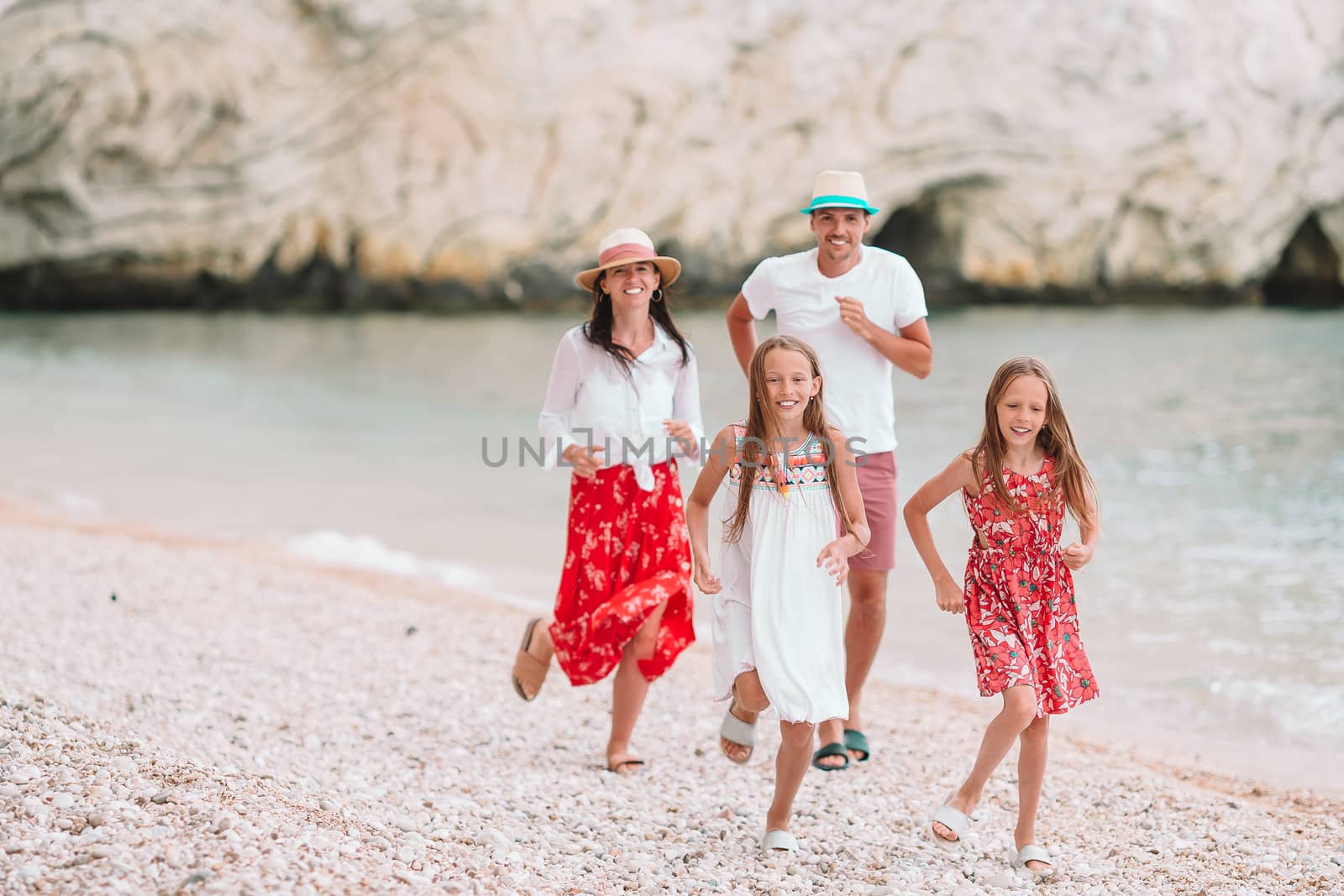 Photo of happy family having fun on the beach. Summer Lifestyle by travnikovstudio