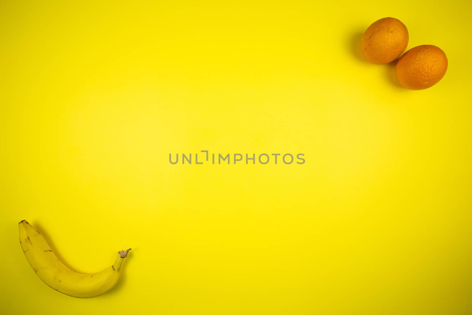 Fruit banana and orange on a yellow background, fruits