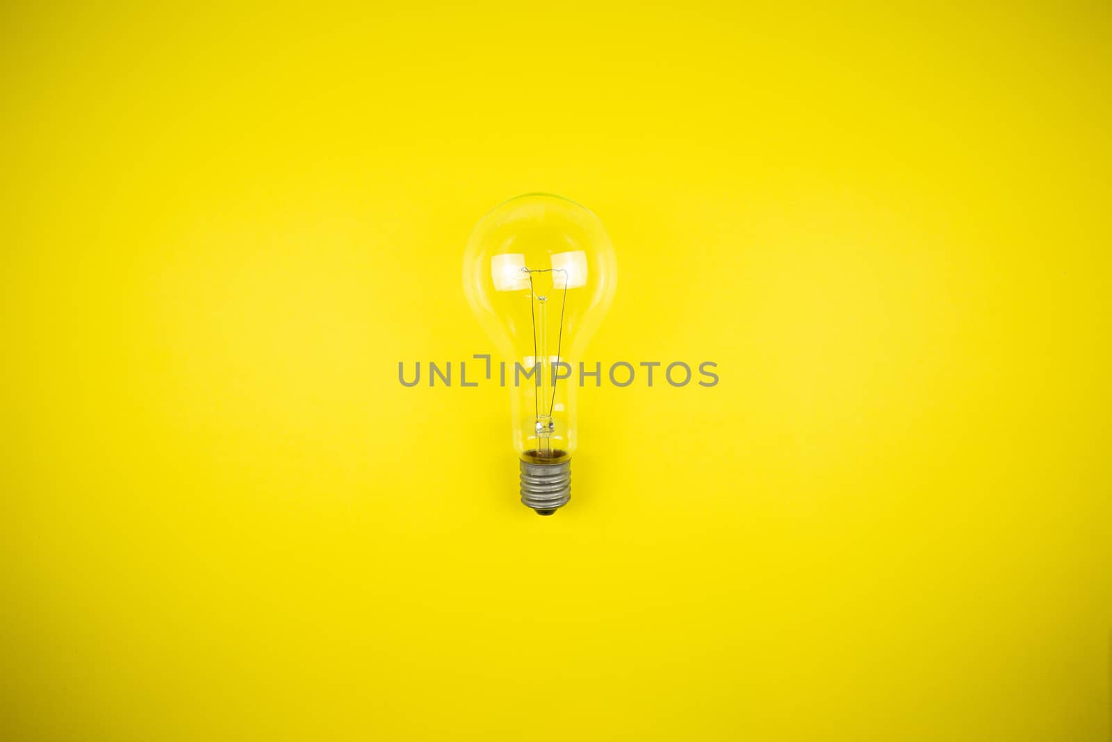 An idea came up. Light bulb on a yellow background by Grinchenkophoto