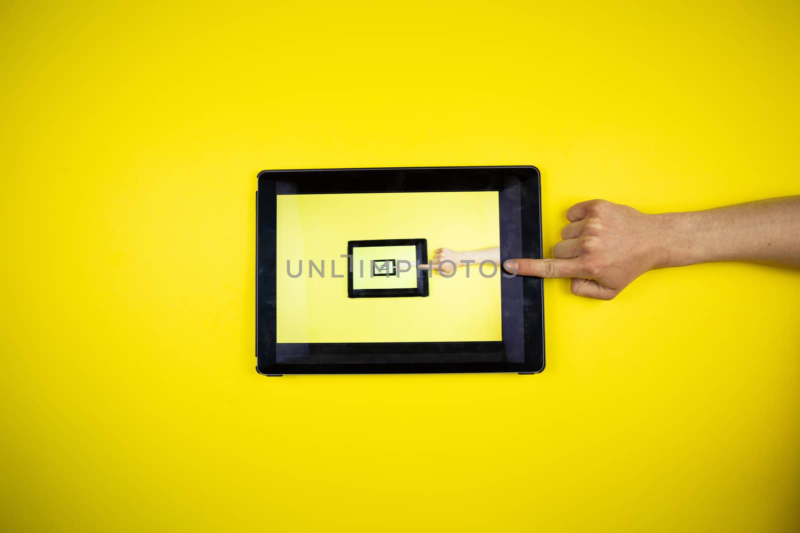 Tablet in hands on a yellow background. Picture in Picture