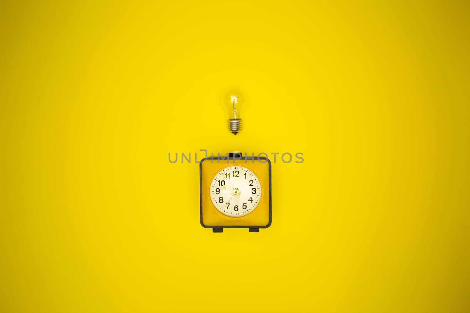 Yellow alarm clock and light bulb