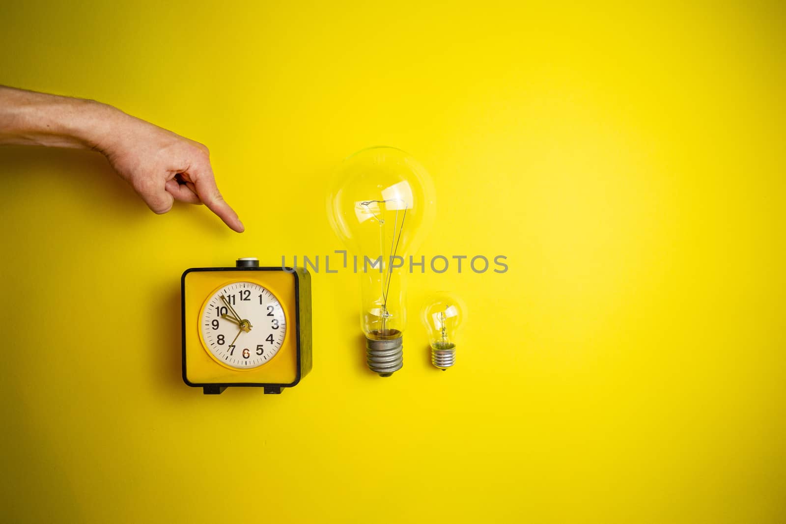 Yellow alarm clock and light bulb