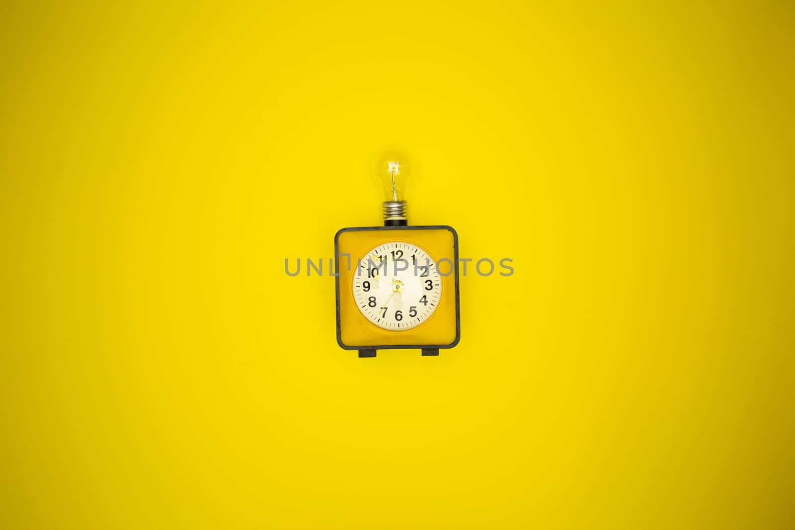 Yellow alarm clock and light bulb