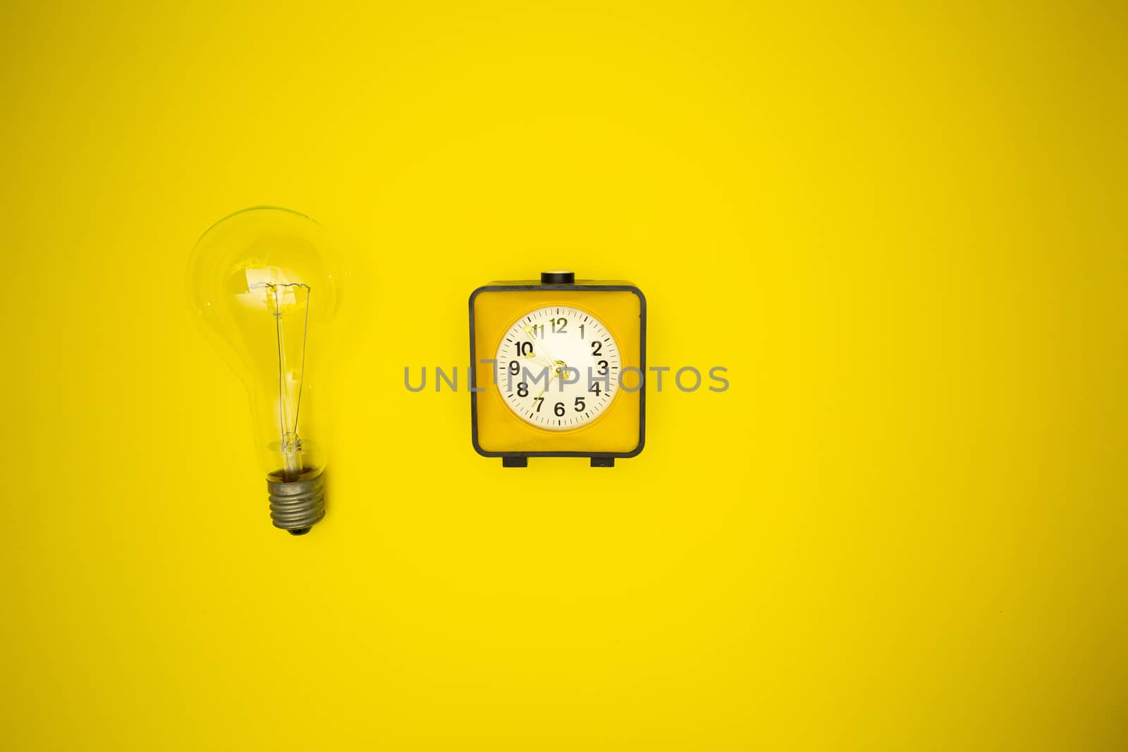 Yellow alarm clock and light bulb