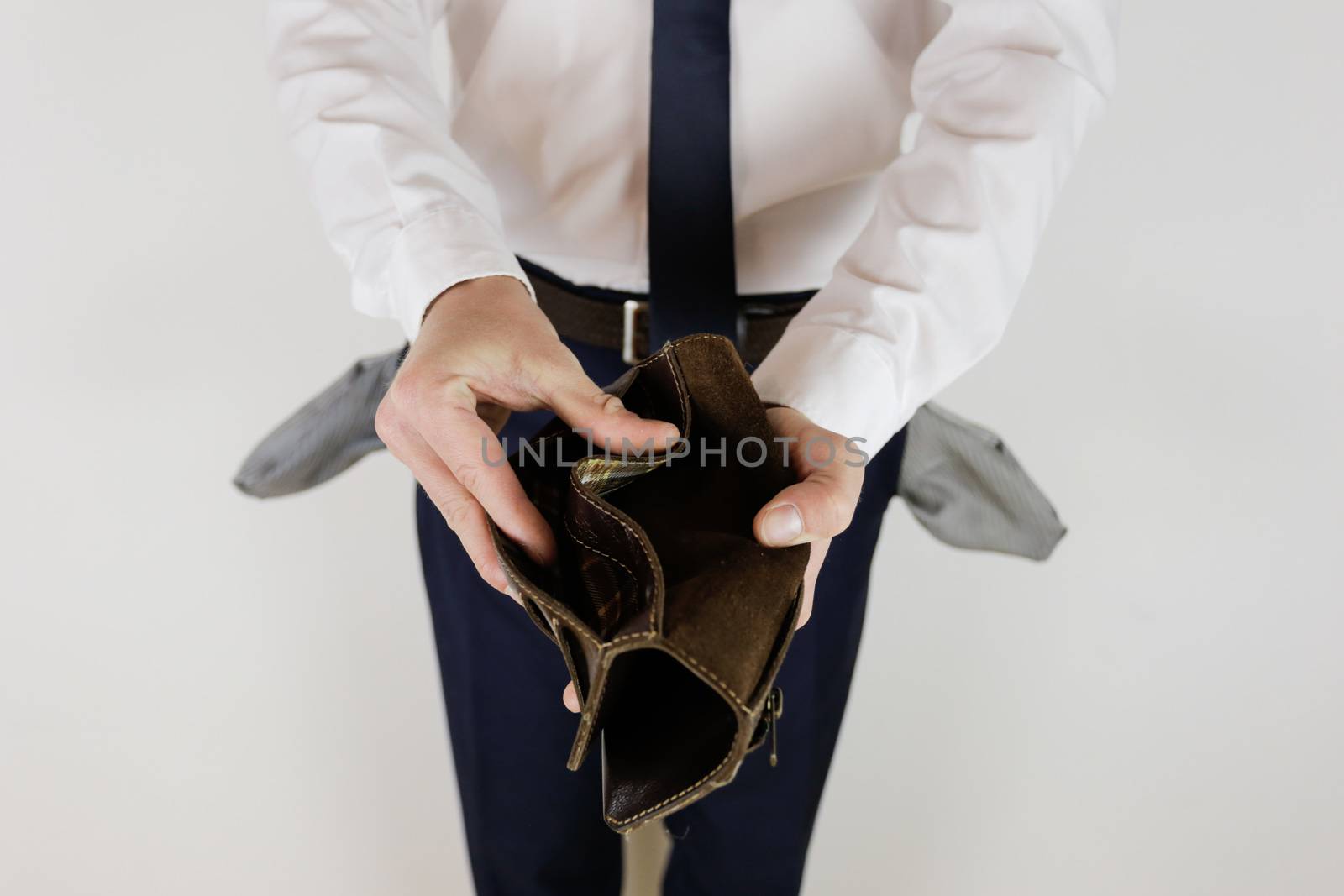 A man in a business suit holds in his hands an empty wallet without money. Financial crisis. Bankruptcy in business. The employer is disappointed.