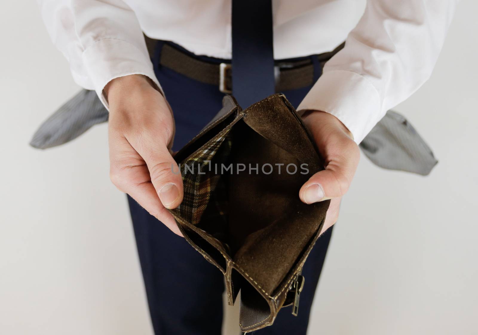 A man in a business suit holds in his hands an empty wallet without money. Financial crisis. Bankruptcy in business. The employer is disappointed.