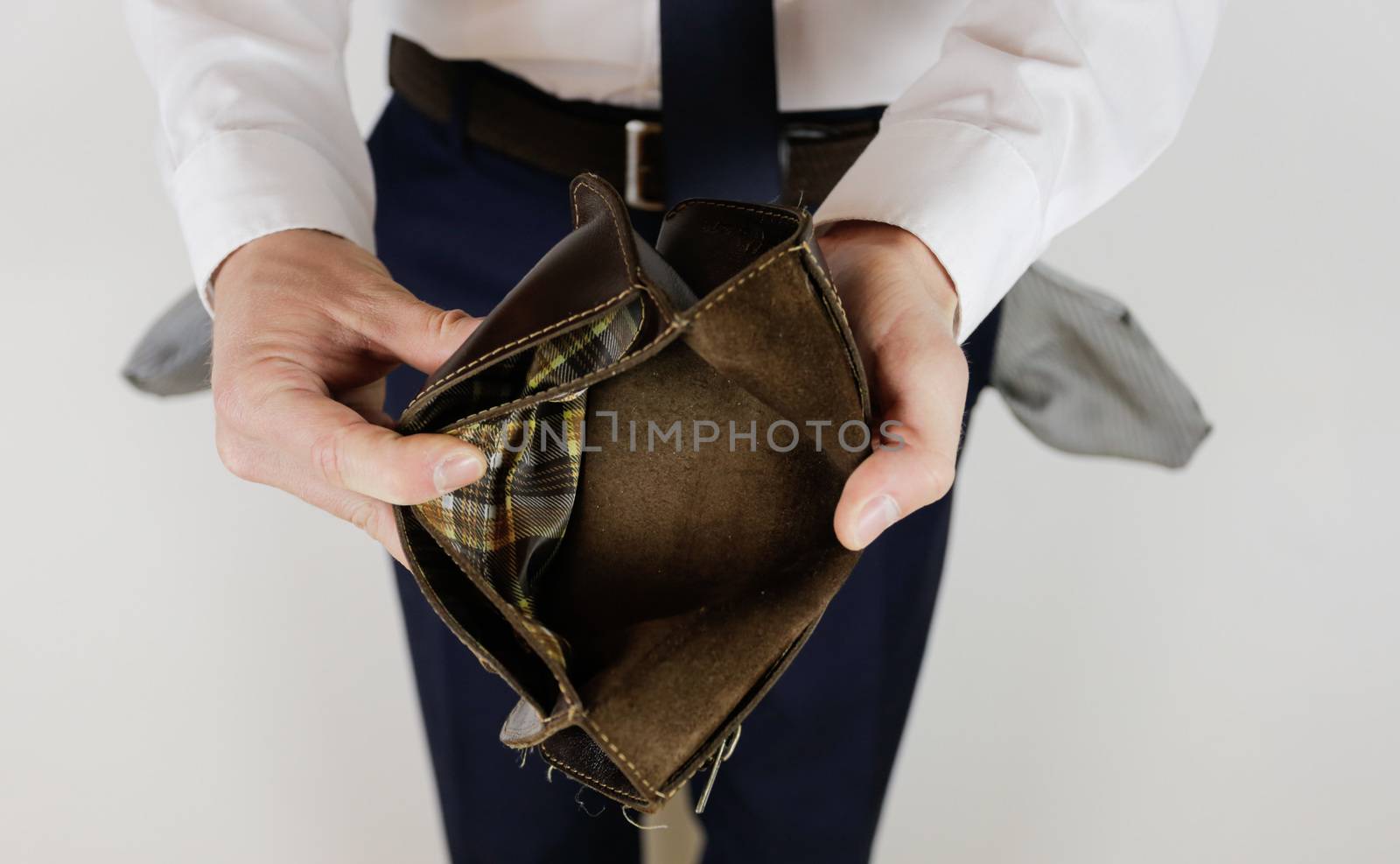 A man in a business suit holds in his hands an empty wallet without money. Financial crisis. Bankruptcy in business. The employer is disappointed.
