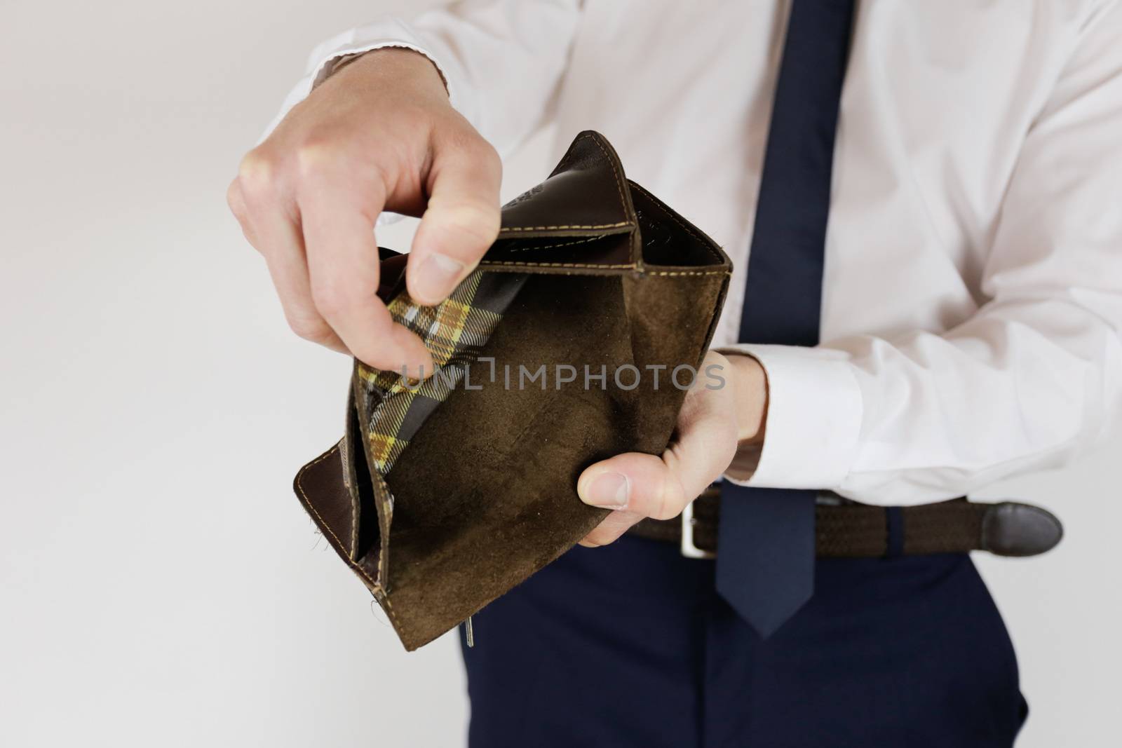 A man in a business suit holds in his hands an empty wallet without money. Financial crisis. Bankruptcy in business. The employer is disappointed.