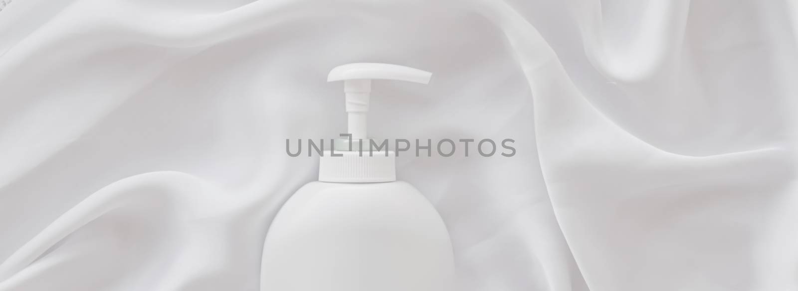 Blank label cosmetic container bottle as product mockup on white silk background by Anneleven