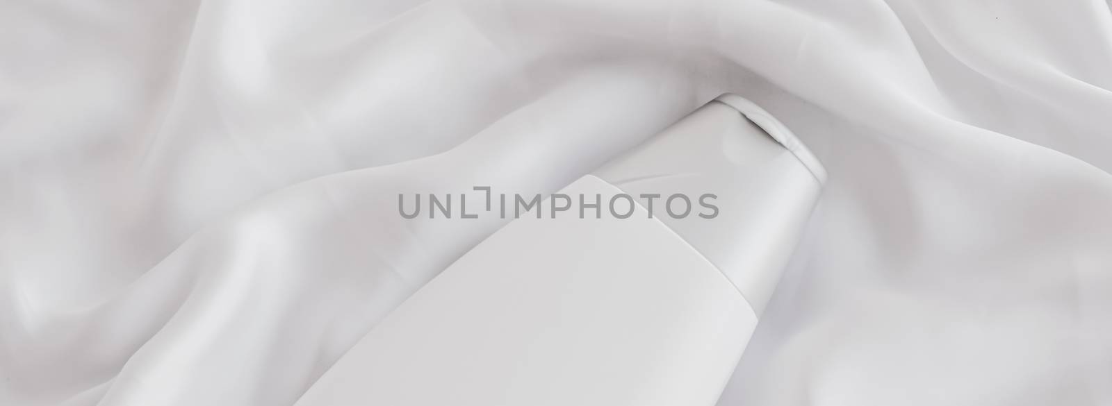 Blank label cosmetic container bottle as product mockup on white silk background by Anneleven