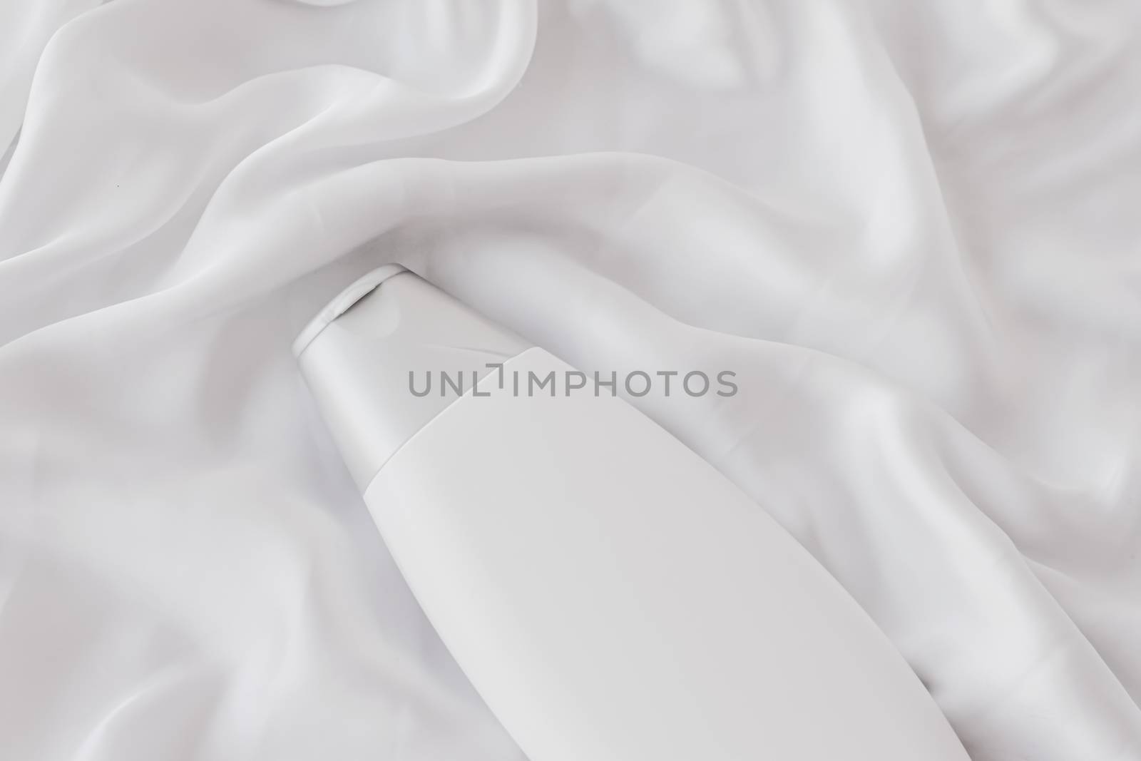 Blank label cosmetic container bottle as product mockup on white silk background, hygiene and healthcare
