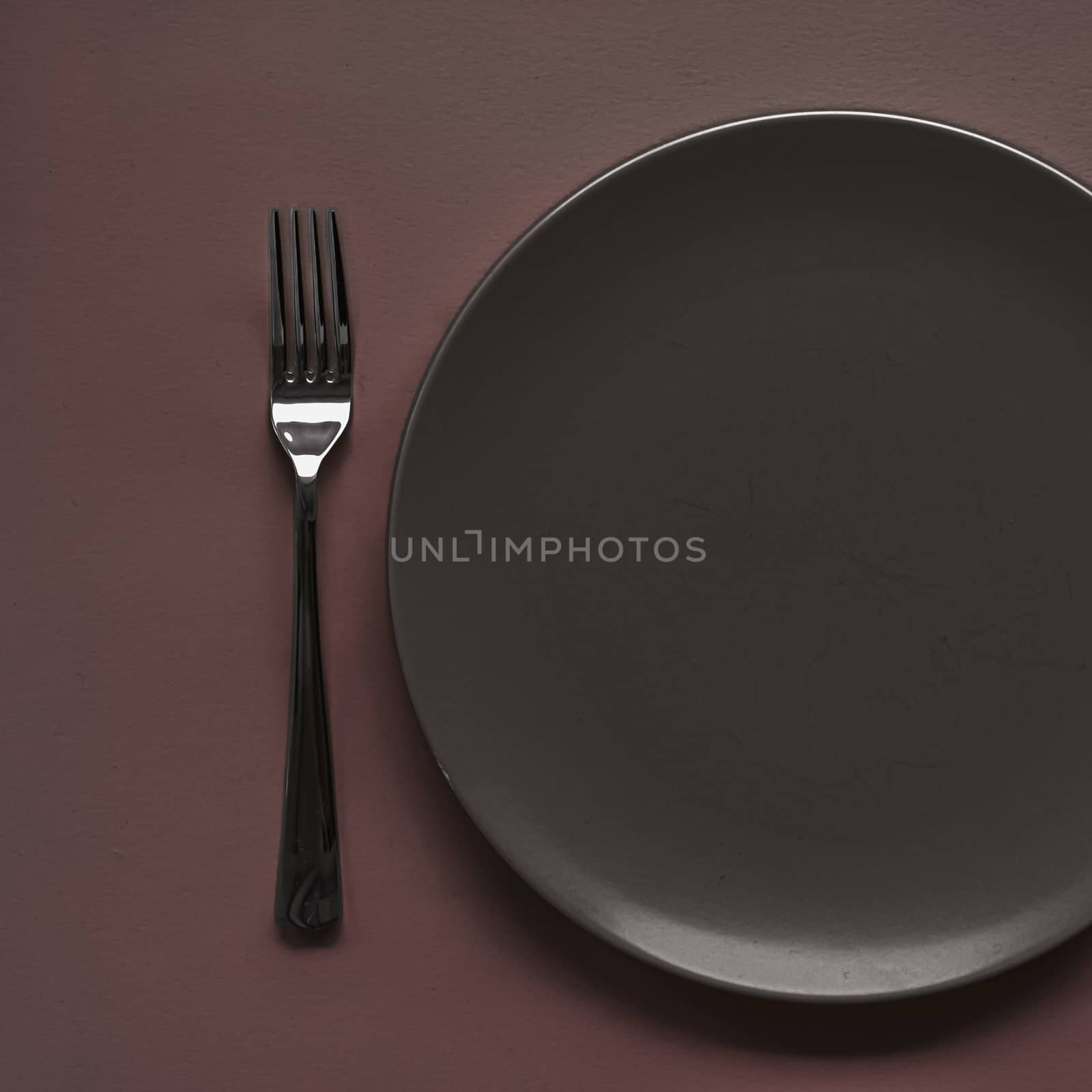 Empty plate and cutlery as mockup set on dark brown background, top tableware for chef table decor and menu branding design