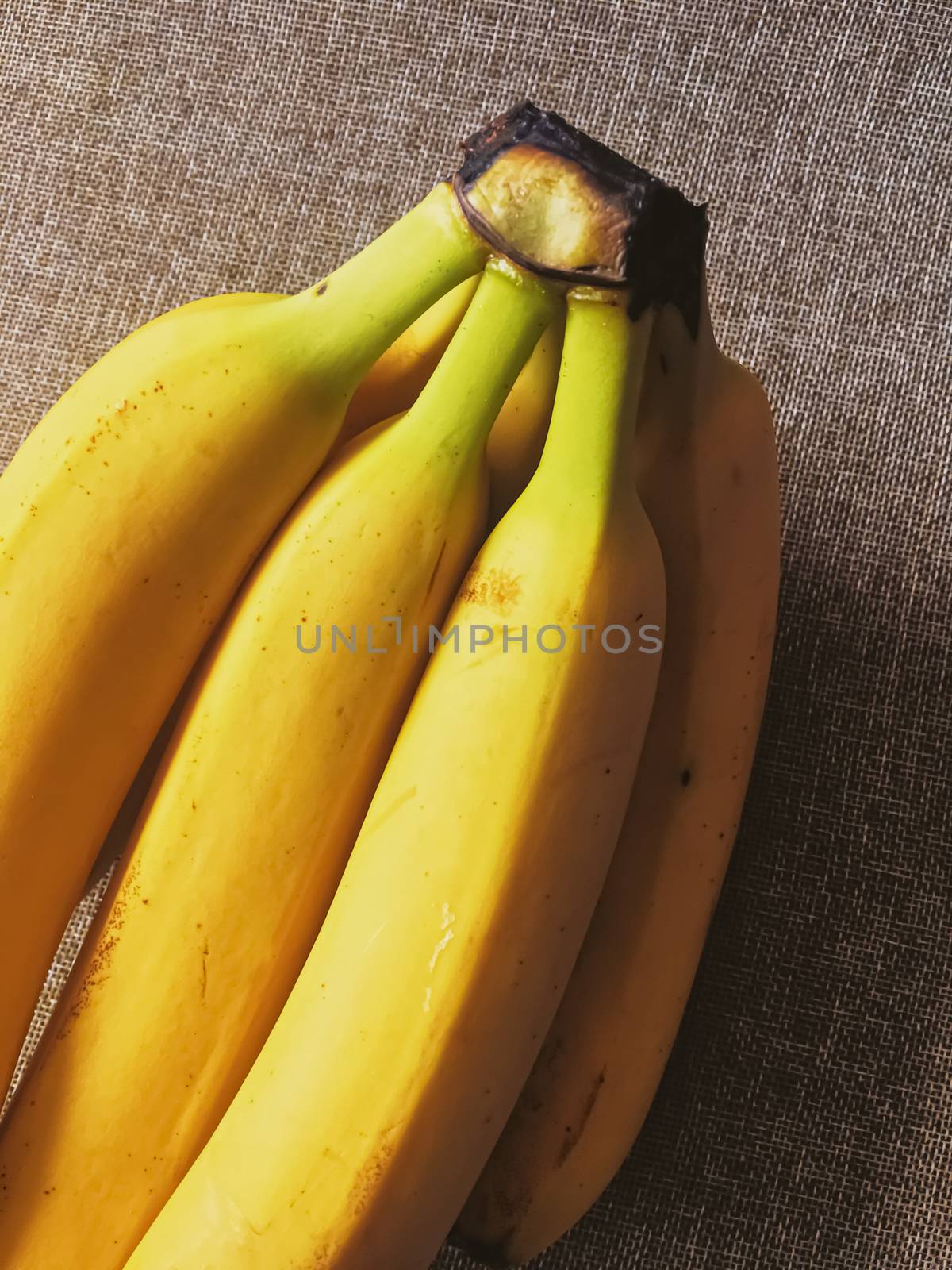 Organic bananas on rustic linen background by Anneleven