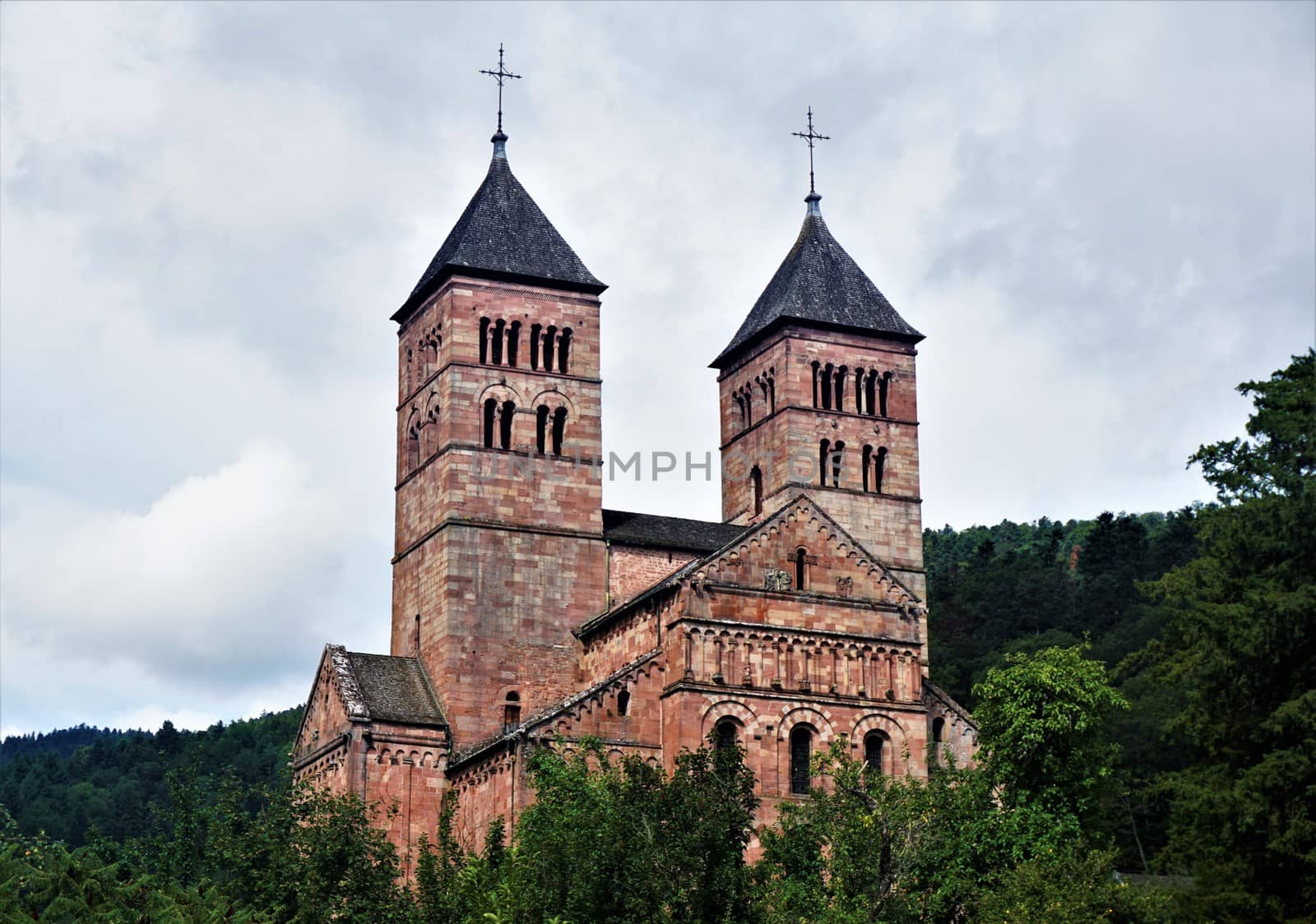 Steeples of Murbach Abbey looming out of the forest in the Vosges, France