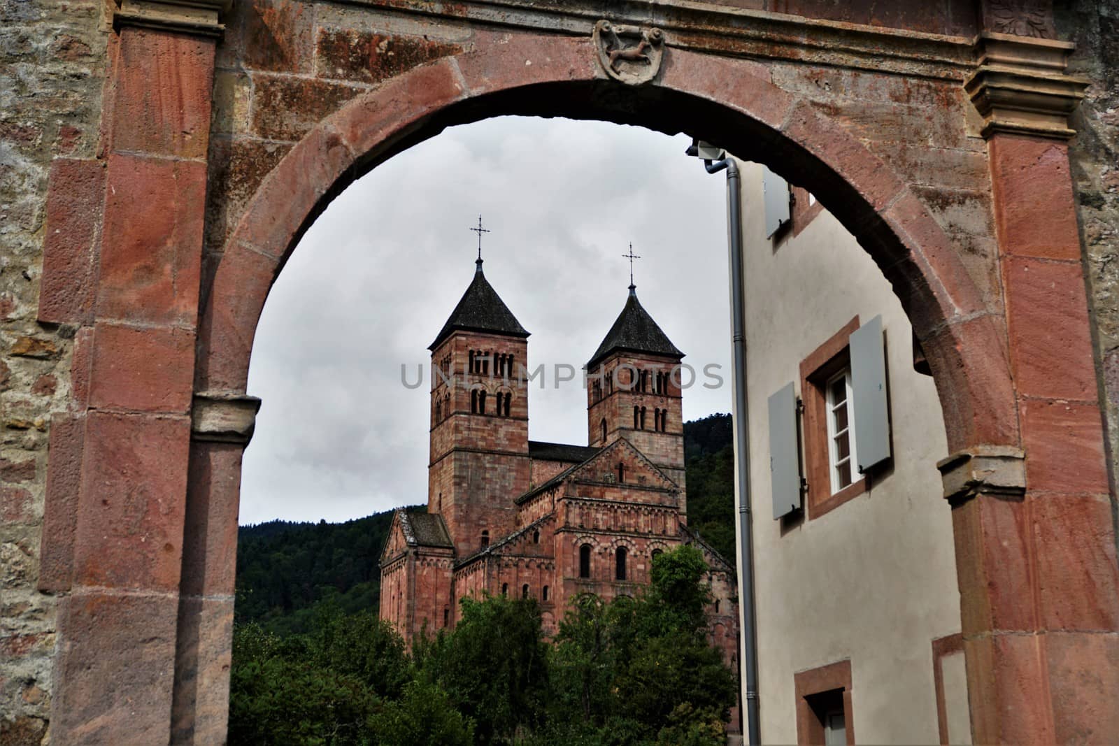 View to Murbach Abbey through a red stone arch