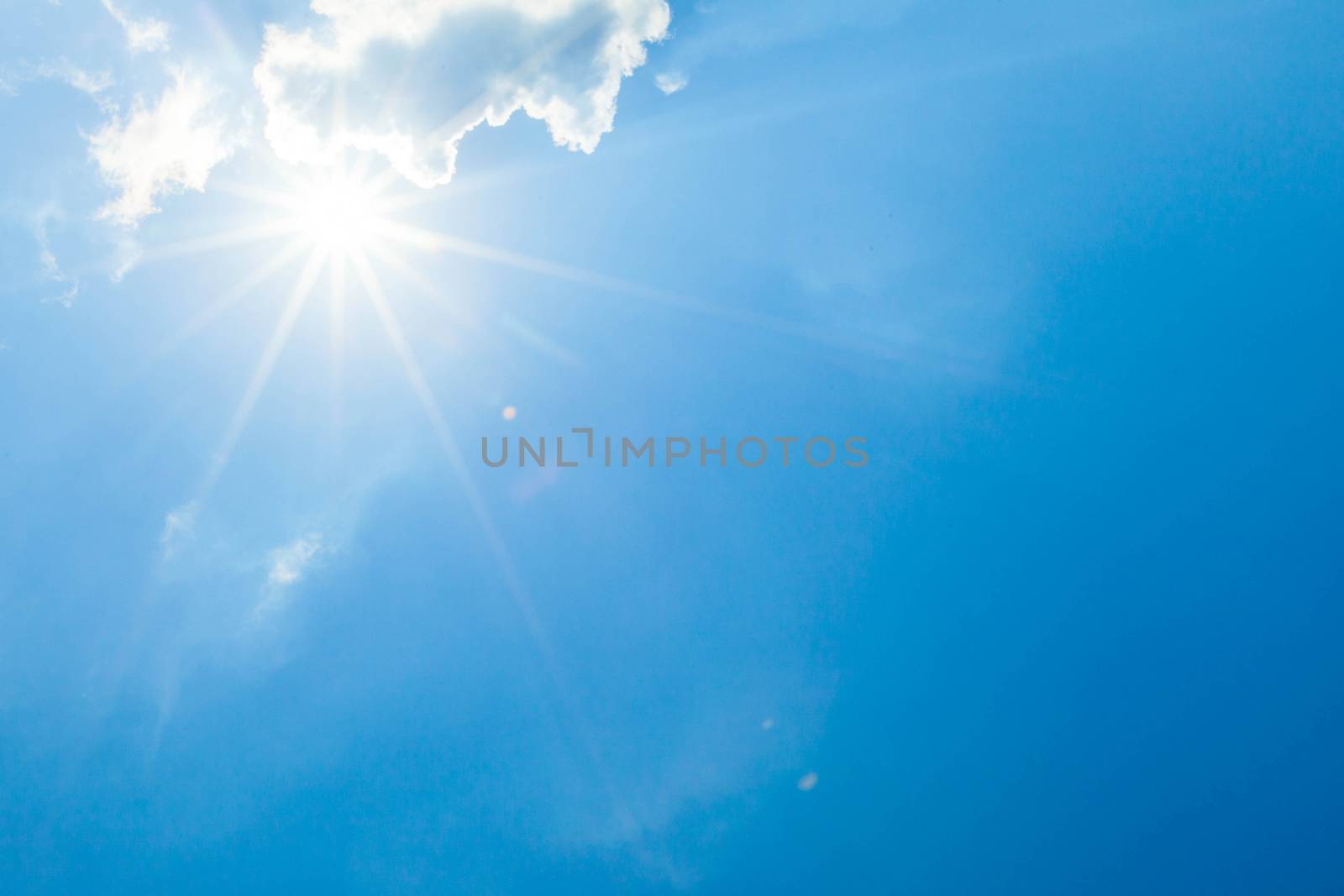 Blue sky with clouds and sun lens flare effect copy space for text